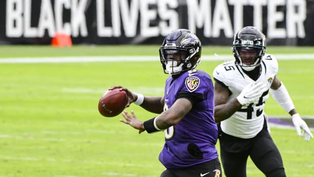 Dec 20, 2020; Baltimore, Maryland, USA; Baltimore Ravens quarterback Lamar Jackson (8) throws to wide receiver Dez Bryant (not pictured) for a second quarter touchdown as Jacksonville Jaguars linebacker K'Lavon Chaisson (45) defends at M&T Bank Stadium.